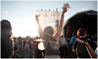 Photographie d'une festivalière avec un pistolet à bulles dans la fosse des Décibulles